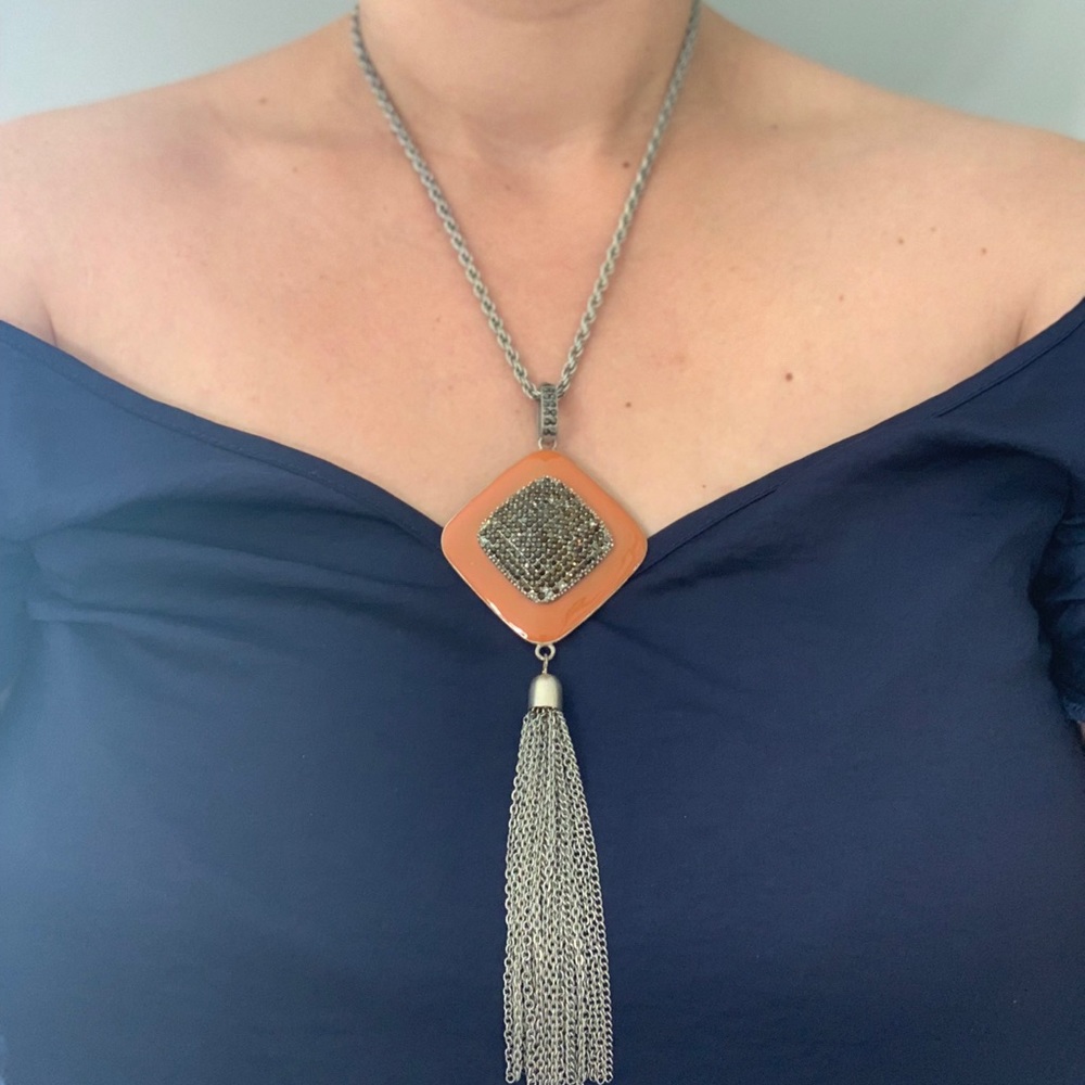 Silver and burnt orange pendant tassel necklace.
